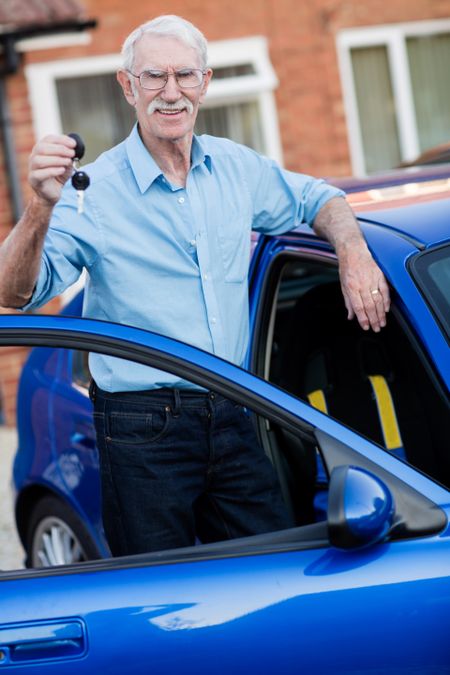 Man holding the keys of his car and looking happy
