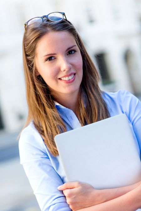 Beautiful female intern with a laptop outdoors