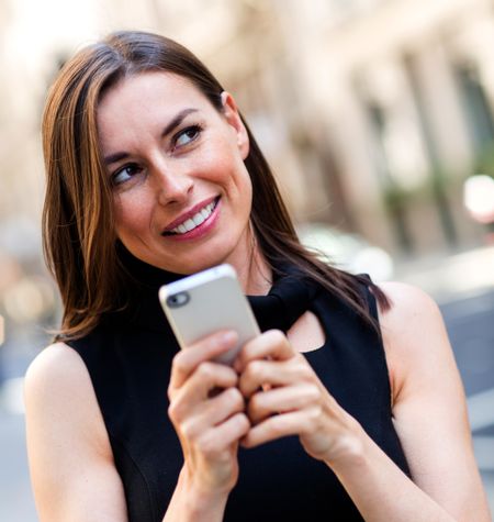 Woman replying a text message on her mobile phone