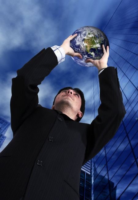business man holding a globe up with the sky in the background