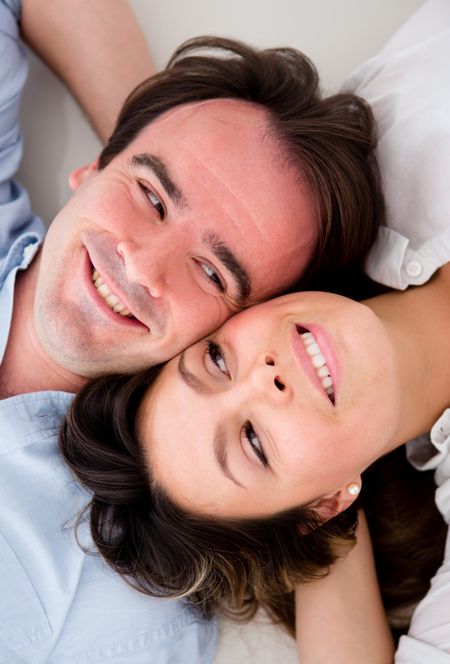 Beautiful couple lying on the floor with heads together