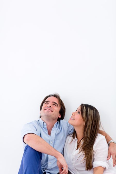 Thoughtful couple looking up - isolated over a white background