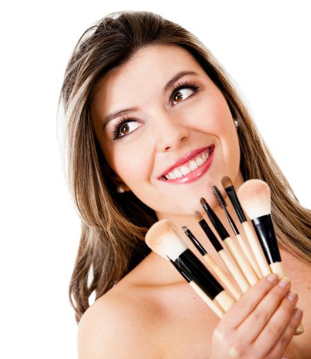 Beauty portrait of a woman holding make up brushes - isolated over a white background