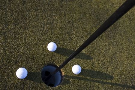 Three golf balls near the pin