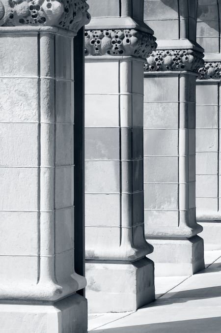 Ornate columns, one with rain gutter, before a portico