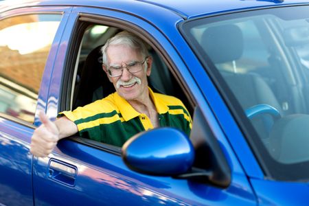 Senior man driving a car and looking very happy