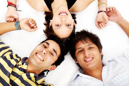 girl and two men smiling on the floor looking happy isolated over a white background
