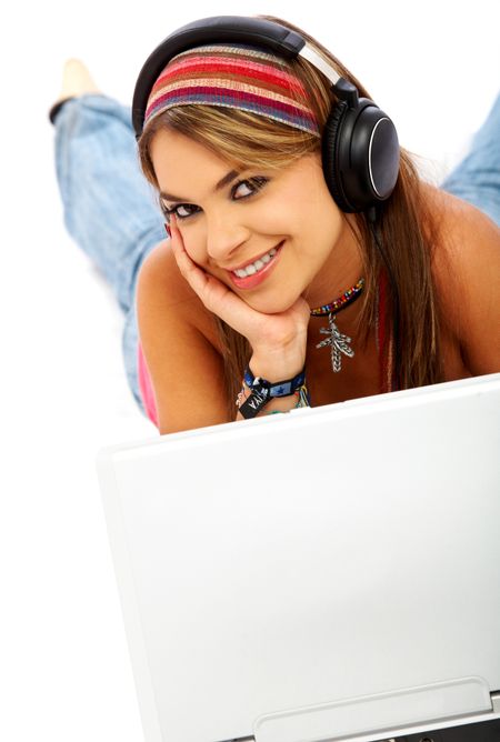 Casual student smiling and listening to music on the computer while studying isolated over a white background