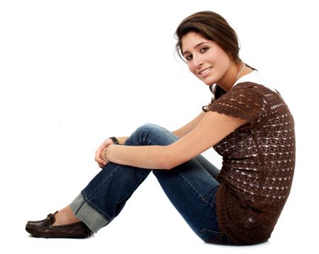 casual woman smiling sitting on the floor isolated over a white background