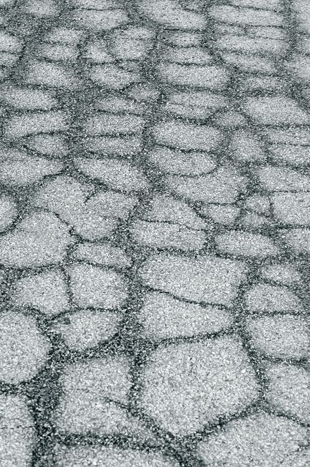 Asphalt pavement weathered into a pattern of cracks
