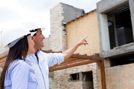 Engineers at a construction site pointing one house