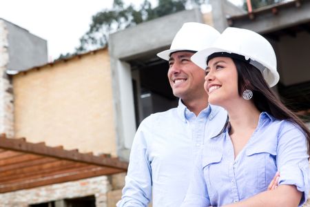 Couple in a construction site looking at house