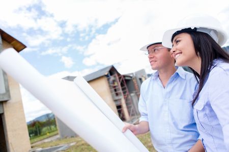 Engineers looking at house project and holding blueprints