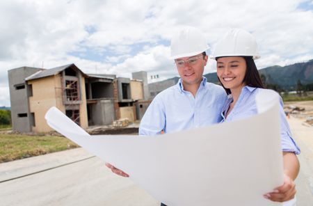 Civil engineers looking at blueprints in a building site