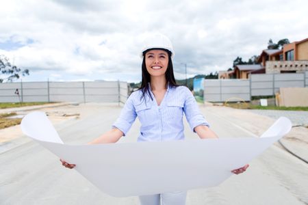 Woman looking at house blueprints in a construction site