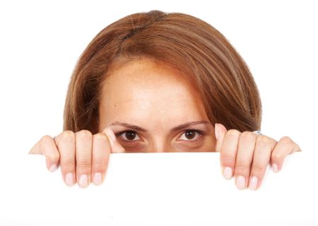 casual woman peeping over billboard sign isolated over a white background
