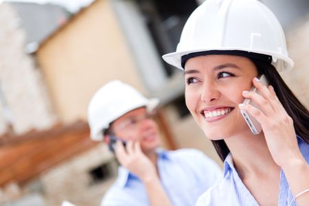 Architects talking on the phone at a building site