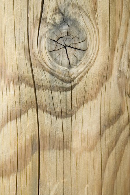 Wood grain with knot and cracks in weathered post