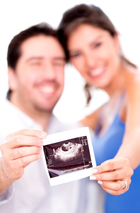 Proud pregnant couple holding an ultrasound and smiling