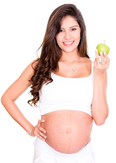 Healthy pregnant woman holding an apple - isolated over white