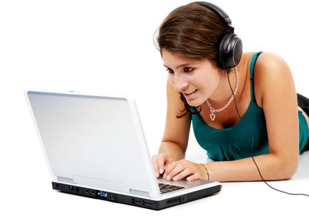 Casual student listening to music on the computer while studying isolated over a white background