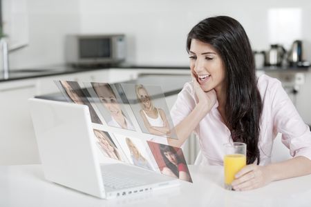 Girl using laptop at home to chat with friends, displaying a concept of her friends profiles.