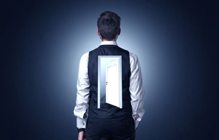 Young businessman standing and thinking with an open door on his back