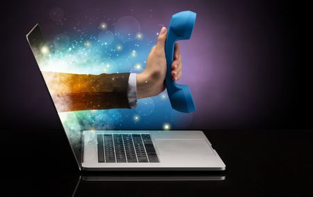 Hand with phone coming out of a laptop with sparkling effects