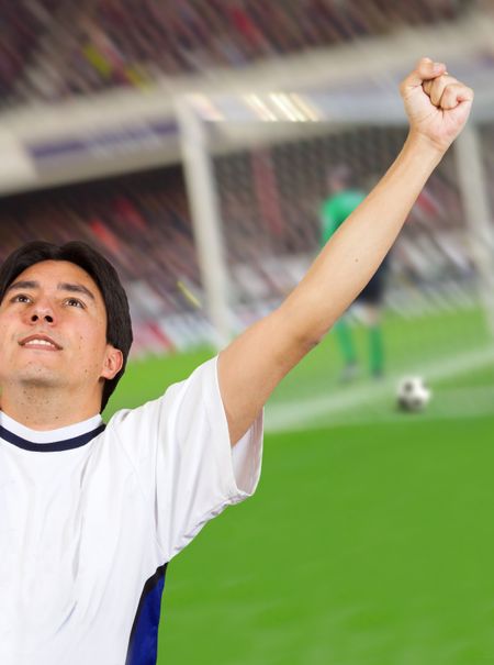 footballer celebrating a goal with a photo of a game at the back, digitally manipulated