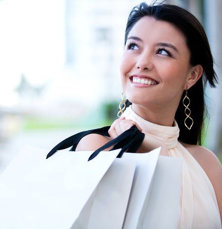Beautiful female shopper holding shopping bags