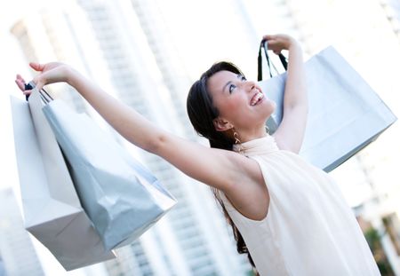 Happy female shopper with arms up and smiling