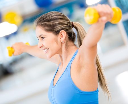Fit woman lifting free weights at the gym