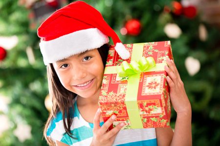 Little girl with a Christmas gift looking happy