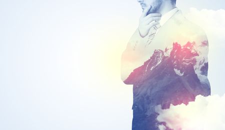 Businessman standing and thinking with snowy mountain graphic