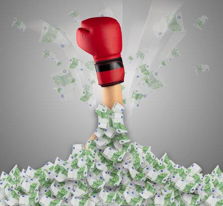 Human hand buried in euro pile and trying to break out