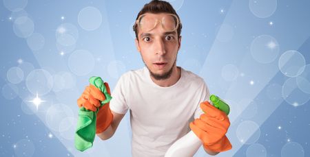 Glittered blue background with male housekeeper and cleaning equipment