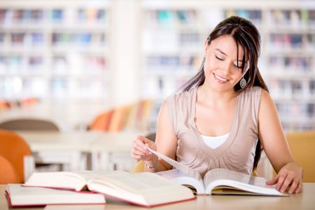 Girl at the library reading a book and smiling