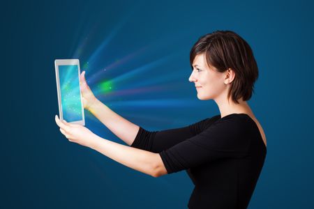 Young business woman looking at modern tablet with abstract lights