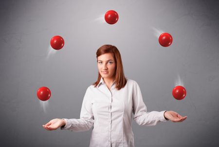 pretty young girl standing and juggling with red balls