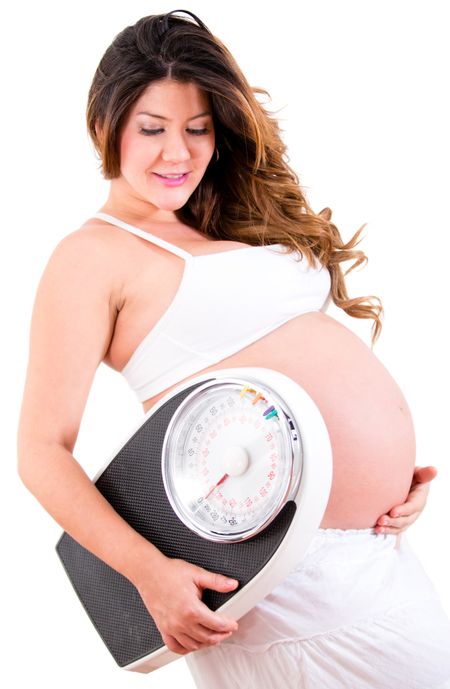 Pregnant woman holding a weight scale - isolated over a white background