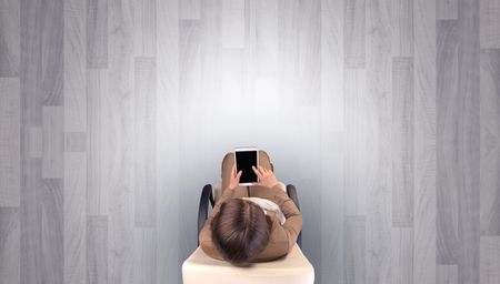 Empty office with woman in a chair and device on her hand