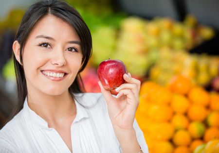 Woman buying organic apples at the supermarket