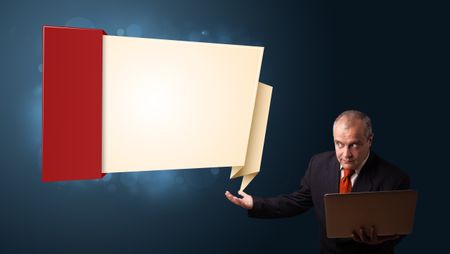 Businessman in suit holding a laptop and presenting modern origami copy space