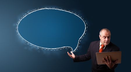 businessman in suit holding a laptop and presenting speech bubble copy space