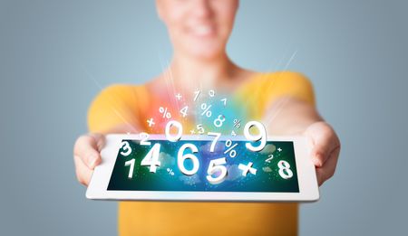Beautiful young woman holding tablet with numbers