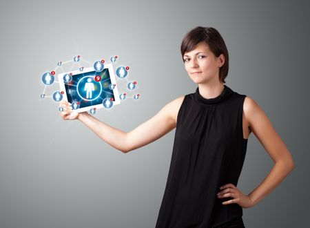 Beautiful young woman holding tablet with social network icons