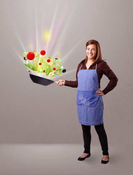 Beautiful young woman cooking fresh vegetables with abstract lights