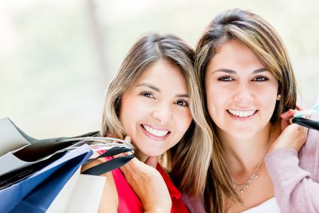 Happy women shopping at the mall and holding bags