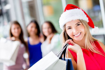 Happy woman Christmas shopping wearing Santa hat