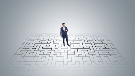 Elegant businessman looking for a solution in a middle of a maze